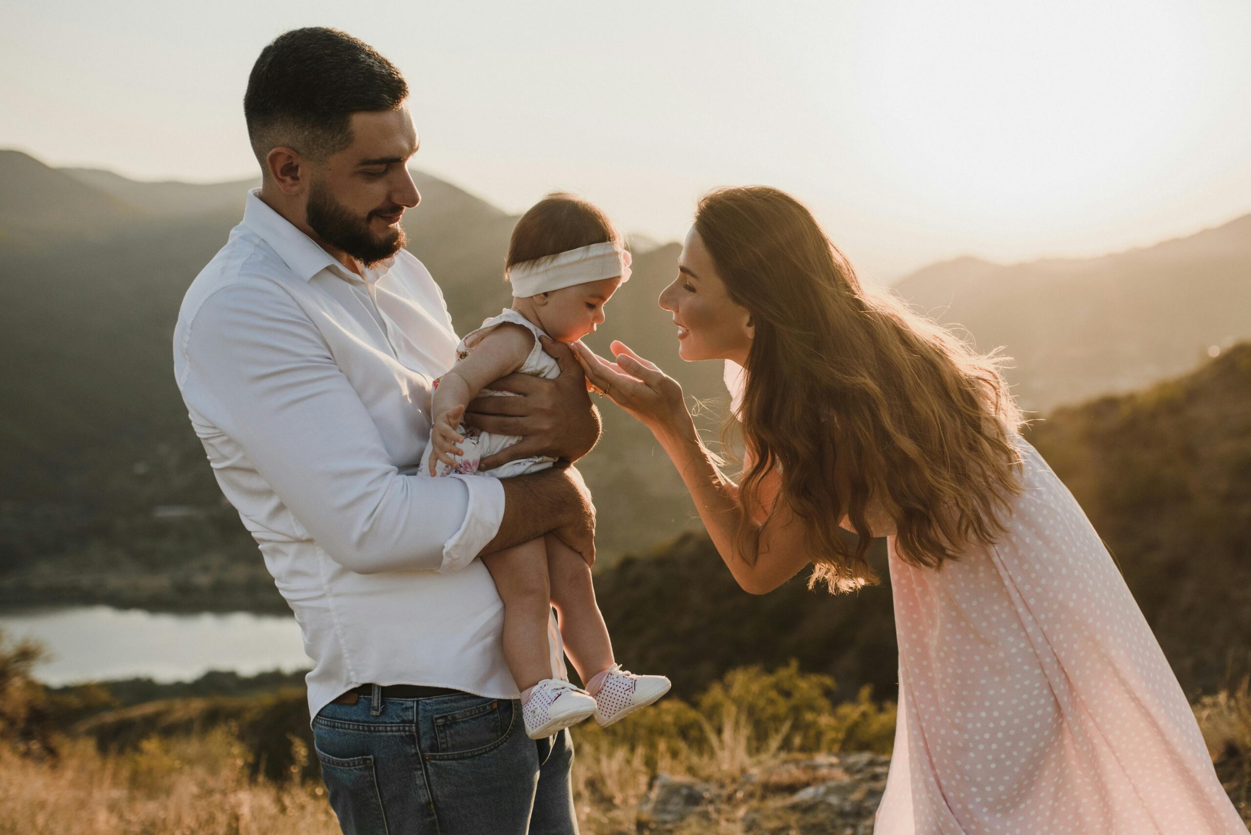 A loving family enjoys a serene sunset moment together in nature.